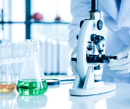 Wissenschaftlicher Student am UKR arbeitet mit Reagenzen und Mikroskop