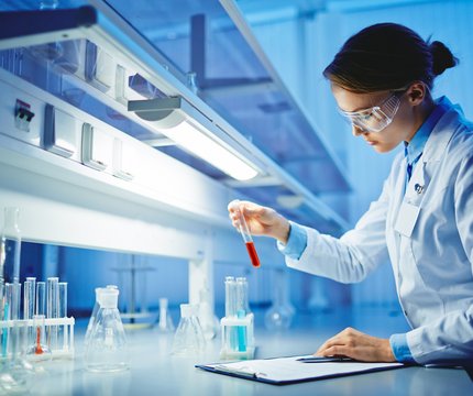 Wissenschaftlerin arbeitet mit Reagenzglas im Labor