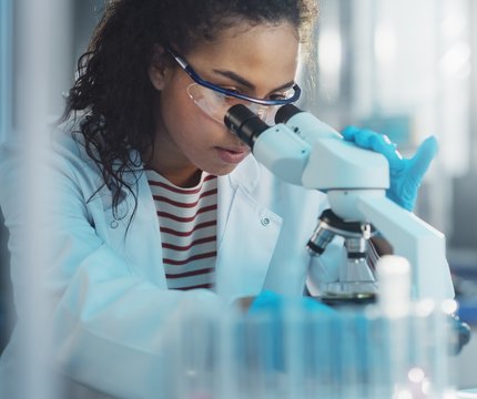 Medizinische Technologin für Laboratoriumsanalytik in Ausbildung am UKR analysiert Probe durch ein Mikroskop