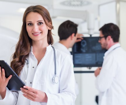 Ärztin mit Tablet vor Röntgengerät